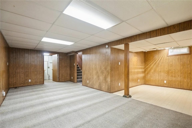 2901 J St SW, Cedar Rapids, IA 52404 - basement featuring stairs, a drop ceiling, carpet floors, and wood walls
