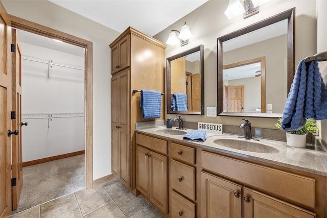 345 Shannon Dr, Robins, IA 52328 - bathroom with double vanity, tile patterned floors, and a walk in closet