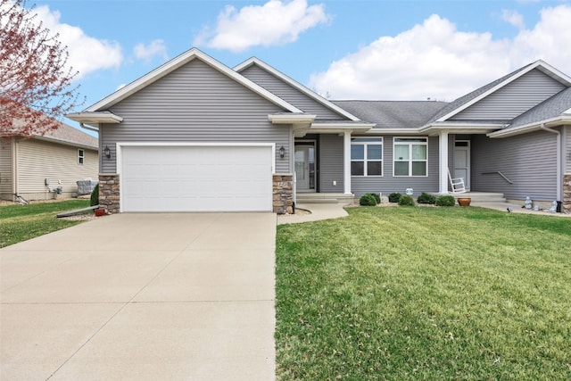 345 Shannon Dr, Robins, IA 52328 - view of front of house with an attached garage, concrete driveway, a front yard, and stone siding