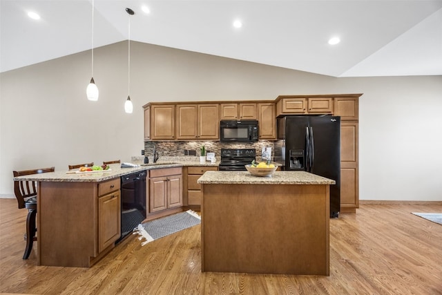 345 Shannon Dr, Robins, IA 52328 - kitchen featuring black appliances, a peninsula, light wood-style floors, high vaulted ceiling, and a kitchen island