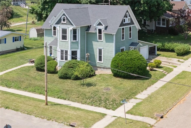 1802 9th Ave, Belle Plaine, IA 52208 - victorian home with a garage, a front lawn, and a shingled roof