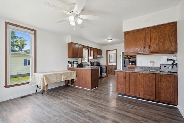 1802 9th Ave, Belle Plaine, IA 52208 - kitchen with stainless steel appliances, a peninsula, healthy amount of natural light, and dark wood-style floors
