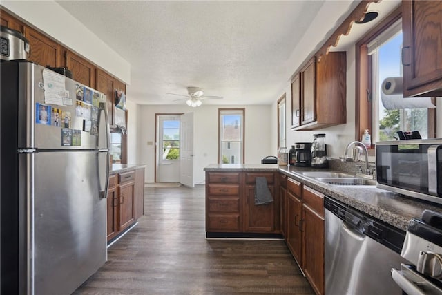 1802 9th Ave, Belle Plaine, IA 52208 - kitchen with stainless steel appliances, ceiling fan, a peninsula, dark wood-style flooring, and a textured ceiling