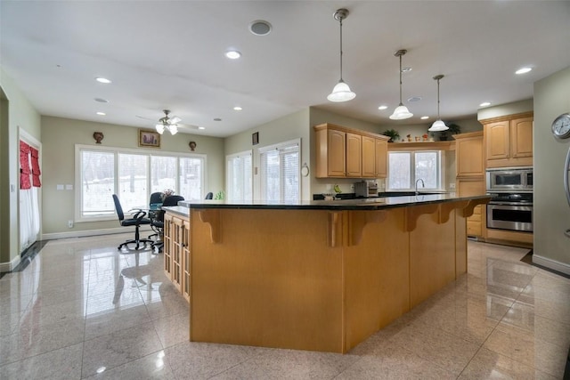 4402 Oak Leaf Ct NE, Cedar Rapids, IA 52411 - kitchen featuring stainless steel appliances, granite tiled floors, a kitchen bar, plenty of natural light, and recessed lighting