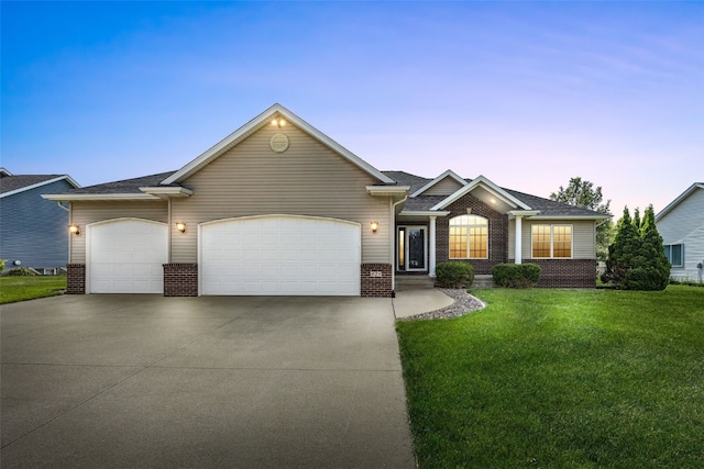 429 W Prairie Dr, Fairfax, IA 52228 - ranch-style home with brick siding, an attached garage, driveway, and a front lawn