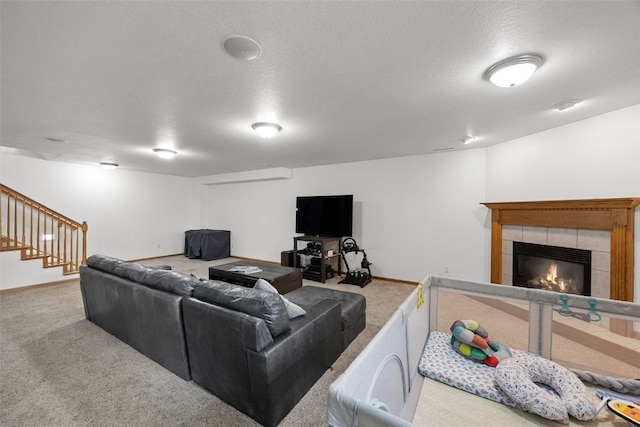 429 W Prairie Dr, Fairfax, IA 52228 - living area with carpet floors, a tiled fireplace, stairs, and a textured ceiling