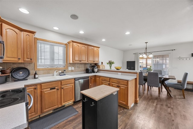 429 W Prairie Dr, Fairfax, IA 52228 - kitchen featuring stainless steel appliances, a peninsula, dark wood-style flooring, a chandelier, and decorative backsplash