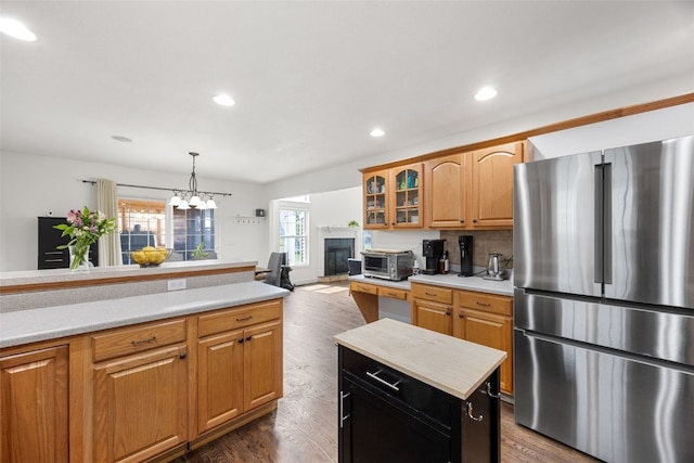 429 W Prairie Dr, Fairfax, IA 52228 - kitchen with freestanding refrigerator, light countertops, glass insert cabinets, dark wood-style floors, and a chandelier