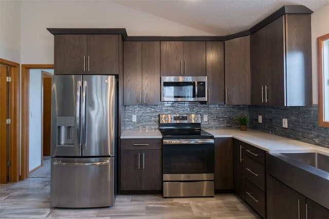 310 34th Ave, Marion, IA 52302 - kitchen featuring stainless steel appliances, dark brown cabinets, backsplash, and lofted ceiling