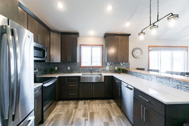 310 34th Ave, Marion, IA 52302 - kitchen featuring stainless steel appliances, a peninsula, tasteful backsplash, dark brown cabinetry, and recessed lighting