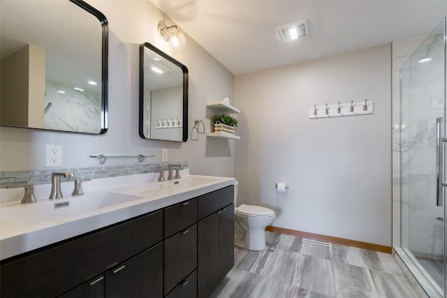 310 34th Ave, Marion, IA 52302 - bathroom featuring double vanity, a marble finish shower, a textured ceiling, and decorative backsplash