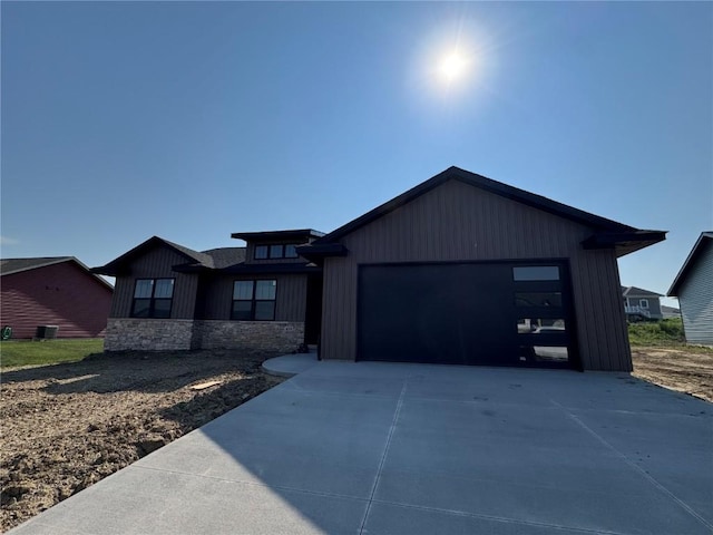 435 Council St, Anamosa, IA 52205 - view of front of property featuring concrete driveway, a garage, and stone siding