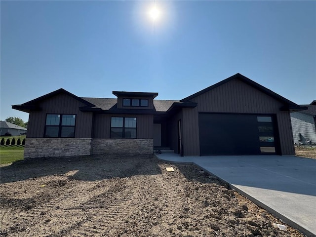 435 Council St, Anamosa, IA 52205 - view of front of house featuring stone siding, an attached garage, and concrete driveway