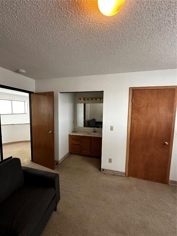 400 1st St SE Unit 410, Cedar Rapids, IA 52401 - bedroom with a textured ceiling and light carpet