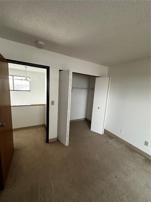 400 1st St SE Unit 410, Cedar Rapids, IA 52401 - unfurnished bedroom featuring carpet flooring, a textured ceiling, and a closet