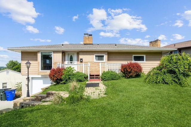 2175 Chandler St SW, Cedar Rapids, IA 52404 - back of property featuring a chimney, a wooden deck, a yard, and a garage