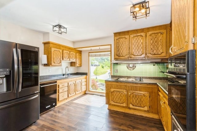 2175 Chandler St SW, Cedar Rapids, IA 52404 - kitchen featuring black appliances, dark countertops, dark wood-style floors, brown cabinetry, and backsplash