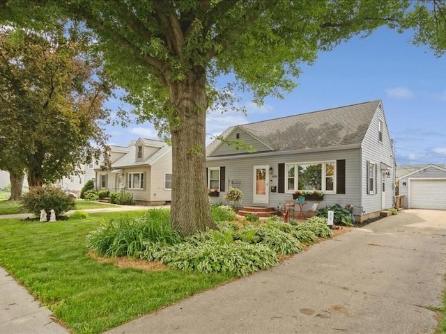 1418 8th St NW, Cedar Rapids, IA 52405 - view of front facade with a shingled roof, an outbuilding, driveway, a front yard, and a detached garage