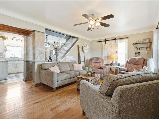 1418 8th St NW, Cedar Rapids, IA 52405 - living area featuring healthy amount of natural light, light wood-style floors, a ceiling fan, and a barn door