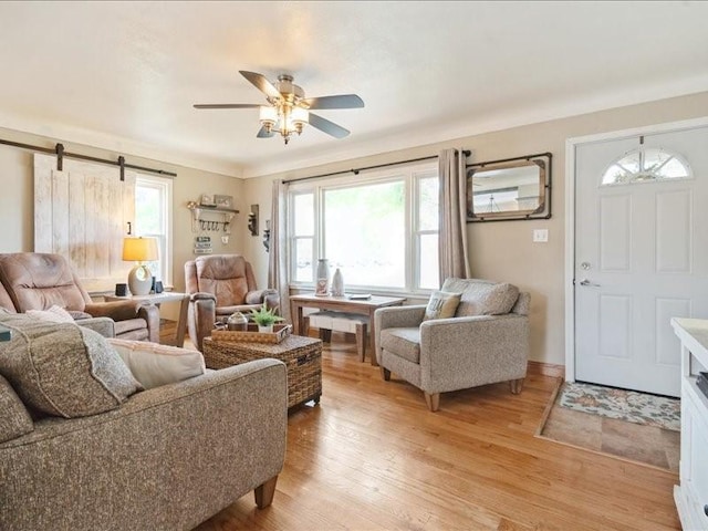 1418 8th St NW, Cedar Rapids, IA 52405 - living room featuring light wood-style flooring, a ceiling fan, and a barn door