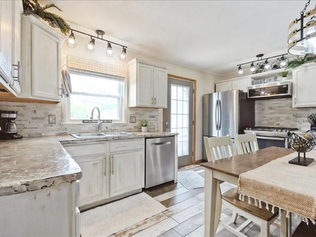 1418 8th St NW, Cedar Rapids, IA 52405 - kitchen with appliances with stainless steel finishes, tasteful backsplash, light countertops, rail lighting, and white cabinetry