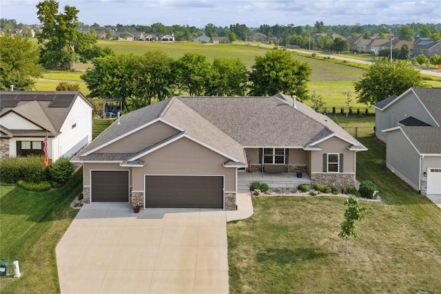 1602 Bridge Creek Ct, Marion, IA 52302 - view of front facade with stone siding, a garage, driveway, a front yard, and a shingled roof