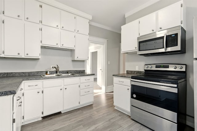 216 15th St NE, Cedar Rapids, IA 52402 - kitchen featuring stainless steel appliances, dark countertops, white cabinets, and crown molding