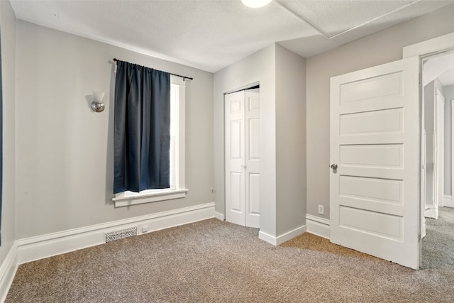 216 15th St NE, Cedar Rapids, IA 52402 - unfurnished bedroom with carpet flooring, a closet, and a textured ceiling