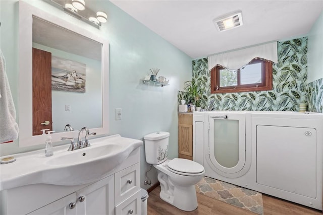 2145 Coldstream Ave NE, Cedar Rapids, IA 52402 - bathroom with wood finished floors, vanity, wallpapered walls, and an accent wall