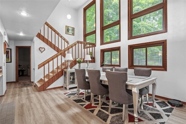 2145 Coldstream Ave NE, Cedar Rapids, IA 52402 - dining area featuring wood finished floors, a high ceiling, and stairs