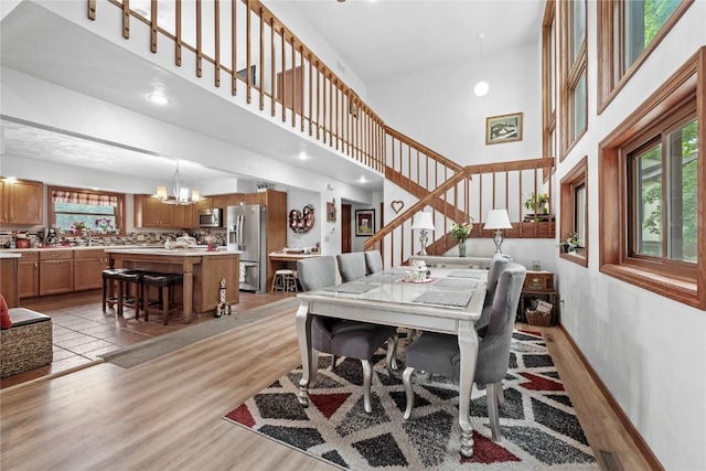 2145 Coldstream Ave NE, Cedar Rapids, IA 52402 - dining space featuring a high ceiling, stairway, a chandelier, and light wood finished floors