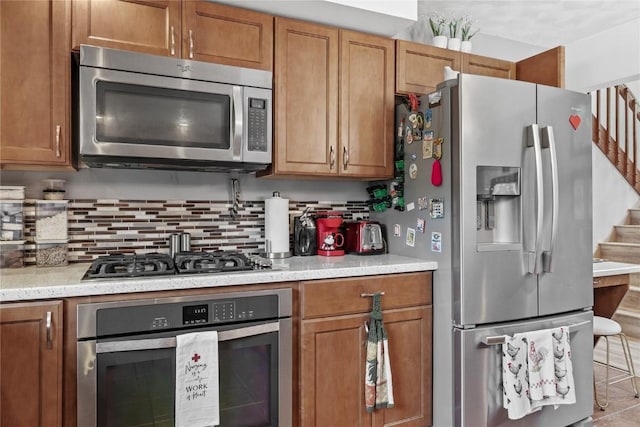 2145 Coldstream Ave NE, Cedar Rapids, IA 52402 - kitchen with appliances with stainless steel finishes, brown cabinetry, and backsplash