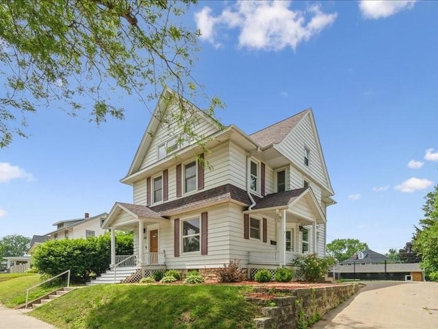 1308 A Ave NW, Cedar Rapids, IA 52405 - view of front facade featuring covered porch, a front yard, and a shingled roof