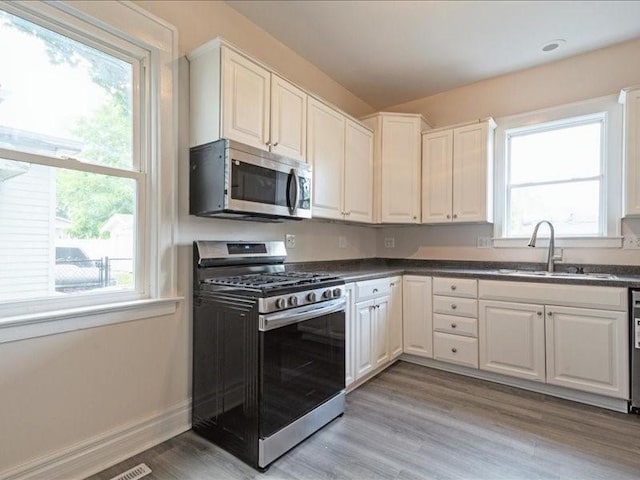 1308 A Ave NW, Cedar Rapids, IA 52405 - kitchen featuring stainless steel appliances, plenty of natural light, dark countertops, and light wood finished floors