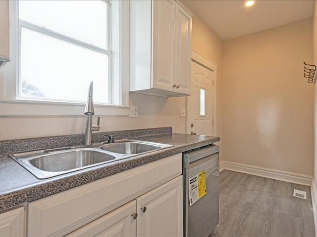 1308 A Ave NW, Cedar Rapids, IA 52405 - kitchen featuring dishwasher, dark countertops, wood finished floors, and white cabinets