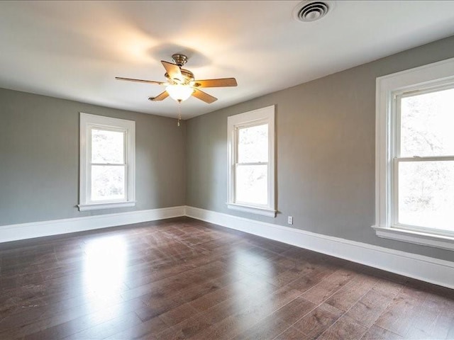 1308 A Ave NW, Cedar Rapids, IA 52405 - empty room with healthy amount of natural light, dark wood finished floors, and ceiling fan