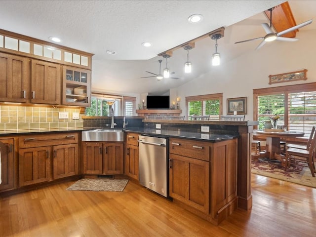 929 Willow Ln Unit A, Lisbon, IA 52253 - kitchen featuring stainless steel dishwasher, a ceiling fan, brown cabinets, a peninsula, and vaulted ceiling