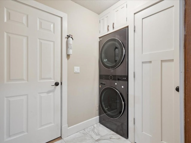 929 Willow Ln Unit A, Lisbon, IA 52253 - washroom featuring estacked washer and dryer, light marble finish flooring, and cabinet space
