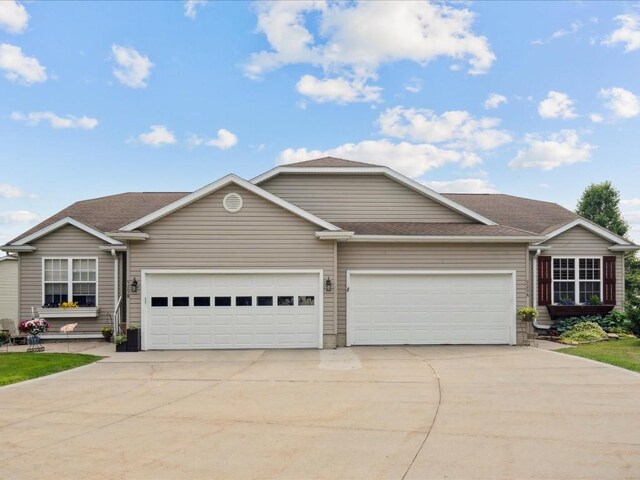 929 Willow Ln Unit A, Lisbon, IA 52253 - view of front of property featuring driveway, an attached garage, and roof with shingles