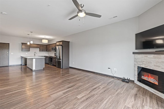 2871 Spring Rose Cir Unit 207, Coralville, IA 52241 - unfurnished living room featuring dark wood-style floors, a ceiling fan, and a fireplace