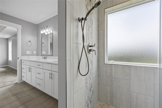 3911 Winnsboro Dr, Iowa City, IA 52245 - bathroom featuring tiled shower, vanity, and wood finished floors