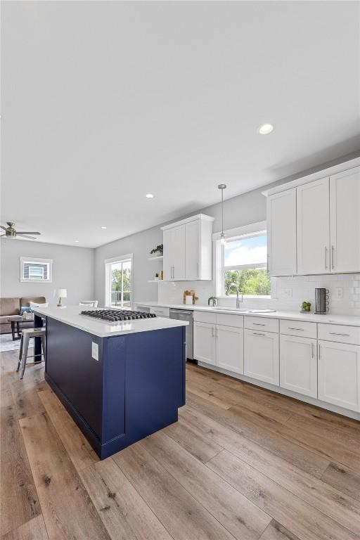 3911 Winnsboro Dr, Iowa City, IA 52245 - kitchen featuring stainless steel dishwasher, white cabinets, gas cooktop, light countertops, and recessed lighting