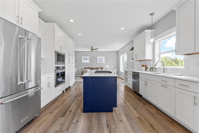 3911 Winnsboro Dr, Iowa City, IA 52245 - kitchen featuring stainless steel appliances, ceiling fan, a kitchen island, plenty of natural light, and recessed lighting