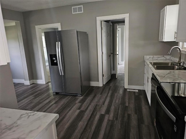 920 E Washington St, Center Point, IA 52213 - kitchen with stainless steel fridge, black range with electric cooktop, dark wood-type flooring, white cabinetry, and a textured ceiling