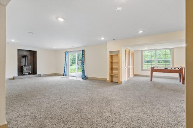 218 Teakwood Ln NE, Cedar Rapids, IA 52402 - unfurnished living room with a wood stove, carpet floors, and recessed lighting