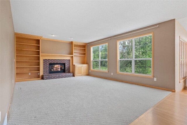 218 Teakwood Ln NE, Cedar Rapids, IA 52402 - unfurnished living room featuring a brick fireplace, wood finished floors, and built in features