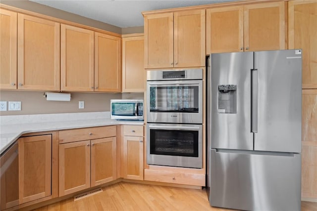 218 Teakwood Ln NE, Cedar Rapids, IA 52402 - kitchen featuring stainless steel appliances, light brown cabinetry, light countertops, and light wood-style flooring