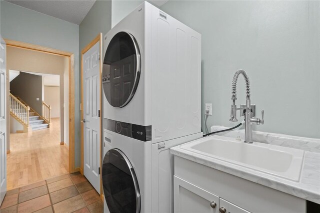 218 Teakwood Ln NE, Cedar Rapids, IA 52402 - laundry area featuring estacked washer and dryer and cabinet space