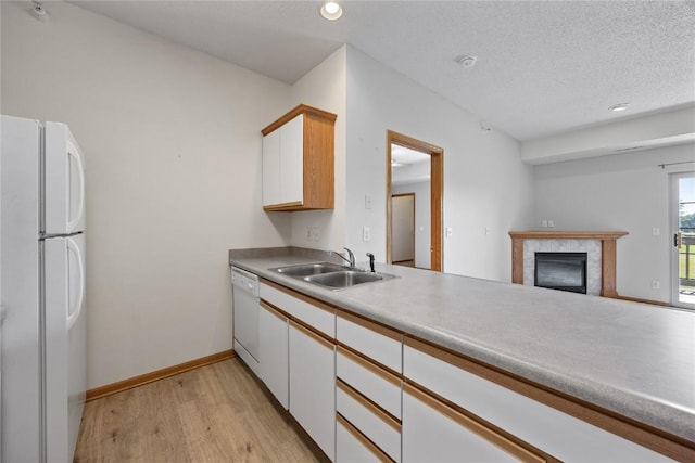 250 Cimarron Dr NE, Hiawatha, IA 52233 - kitchen featuring white appliances, light wood-type flooring, white cabinetry, recessed lighting, and a glass covered fireplace