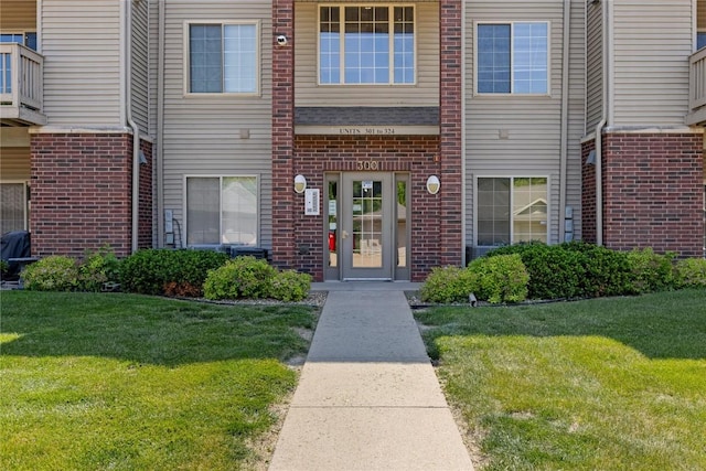 250 Cimarron Dr NE, Hiawatha, IA 52233 - entrance to property featuring brick siding and a lawn
